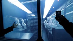 Một khách hàng chụp ảnh  một cánh tay robot thu thập các món ăn đóng gói sẵn từ kho lạnh tại nhà hàng lẩu trí tuệ nhân tạo mới của Haidilao ở Bắc Kinh, Trung Quốc. Ảnh: Reuters