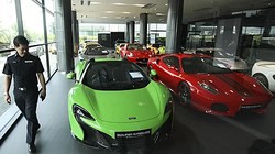 Một viên cảnh sát kiểm tra tại showroom kinh doanh siêu xe đã qua sử dụng bị nghi ngờ buôn lậu ở Thái Lan. Ảnh: Bangkok Post