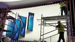 Các công nhân đang thi công poster quảng cáo điện thoại Huawei Mate X (ảnh: Phone Arena)