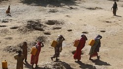 Những người phụ nữ đang mang các can nước được lấy từ giếng đào trên cát dọc theo bờ sông Shabelle, đây là khu vực rất thiếu nước trong mùa hạn tại Somali (Ảnh Reuters)