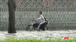 Một nữ sinh ướt hết quần áo khi di chuyển trên tuyến đường ngập sâu ở Hà Nội.