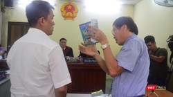 Họa sĩ Lê Linh (áo trắng) và ông Nguyễn Vân Nam (người đang cầm cuốn sách) - đại diện cho công ty Phan Thị với những trao đổi gay gắt tại tòa 