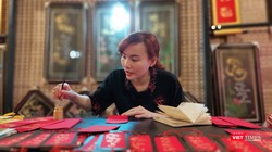 Một nữ thư pháp gia còn rất trẻ đang cho chữ tại phố ông đồ trước Nhà văn hóa Thanh niên 