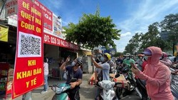 Người dân quét mã khai báo y tế trên điện thoại tại trạm kiểm soát trên đường Nguyễn Kiệm (Gò Vấp) ngày 7/6 (Ảnh: SGGP) 