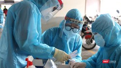 Nhân viên y tế lấy mẫu xét nghiệm trong khu vực phong tỏa - Ảnh: HCDC