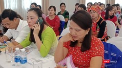 Các đại biểu tại Hội nghị xem sổ theo dõi sức khỏe bà mẹ và trẻ em