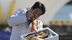 Ông Abe không ngần ngại ăn cá nướng tại tỉnh Fukushima. Ảnh: Reuters