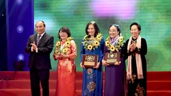 Thủ tướng Nguyễn Xuân Phúc (trái) và Nguyên Phó Chủ tịch nước Nguyễn Thị Doan (phải) tặng hoa cho các phụ nữ điển hình tiên tiến.