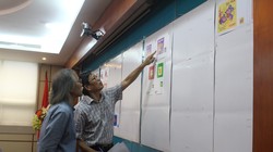 Các thành viên Hội đồng chấm thi xem xét, đánh giá và lựa chọn các mẫu tem Tết. Ảnh: MIC.gov.vn