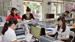 Giao dịch viên phục vụ khách hàng từ mùng Ba Tết. Ảnh: Minh Đàm