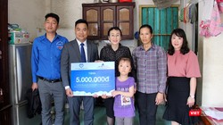 Em Lê Thị Trà My và gia đình nhận phần quà hỗ trợ dành cho trẻ em khuyết tật tiêu biểu. (Ảnh Hương Sen).