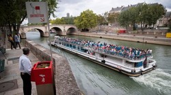 Một người đàn ông đang "giải quyết nỗi buồn" ngay bên cạnh bờ sông Seine (Ảnh: USA today)