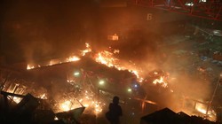 Một người biểu tình đứng quan sát giữ ngọn lửa rừng rực bên trong trường ĐH Bách khoa Hong Kong (Ảnh: Reuters)