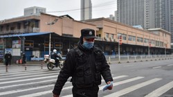 Một sĩ quan cảnh sát tuần tra ở chợ hải sản Huanan, Vũ Hán nơi mà các nhà khoa học tin là khởi điểm của dịch bệnh (Ảnh: Washington Post)