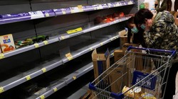 Người tiêu dùng mang khẩu trang đi lung sục các kệ hàng bán mỳ gói để tích trữ (Ảnh: Reuters)