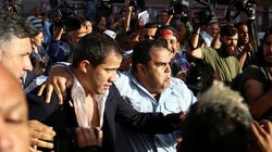 Ông Juan Guaido được hộ tống ra xe để thoát khỏi đám đông người biểu tình ở sân bay (Ảnh: Sputnik)