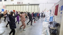 Nhân viên y tế trong trang phục bảo hộ kín mít hướng dẫn các bệnh nhân tập thể dục (Ảnh: Getty)