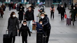 Nhiều hành khách mang khẩu trang chống COVID-19 tại trạm đường sắt ở Bắc Kinh (Ảnh: AFP)