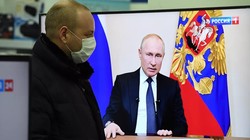 Một người dân theo dõi ông Putin phát biểu trên truyền hình (Ảnh: Sputnik)