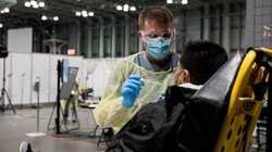 Bác sĩ lấy mẫu bệnh phẩm để xét nghiệm COVID-19 tại thành phố New York ngày 4/4 (Ảnh: Reuters)