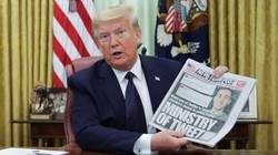 Tổng thống Trump cầm tờ New York Times lúc phát biểu trước phóng viên trong khi chuẩn bị ký sắc lệnh mới (Ảnh: Reuters)