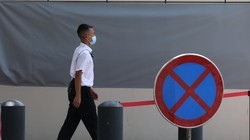 Một nhân viên an ninh băng qua tấm biển cấm vào bên ngoài tòa lãnh sự quán Mỹ ở Thành Đô (Ảnh: SCMP)