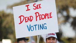 Một người ủng hộ Trump giơ tấm biển với dòng chữ: "Tôi thấy người chết đi bỏ phiếu" (Ảnh: Telegraph)