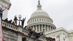 Người biểu tình trèo lên tường tòa nhà Quốc hội Mỹ hòng thâm nhập vào bên trong (Ảnh: Reuters)