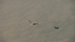 Máy bay ném bom Tu-160 của Nga được hộ tống bởi một chiếc Su-30SM (Ảnh: RT)