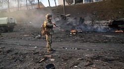 Một binh sĩ Ukraine kiểm tra hiện trường một vụ tấn công của Nga tại Kiev trong sáng 26/2 (Ảnh: AFP)