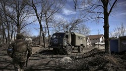 Binh sĩ Ukraine bên cạnh một xe quân sự của Nga bị thu giữ ở Kharkiv (Ảnh: AFP)