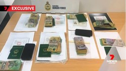 Hình ảnh từ bản tin của 7News thể hiện rõ các cuốn hộ chiếu mang quốc huy Việt Nam trong tang vật vụ việc. (Ảnh cắt từ clip)