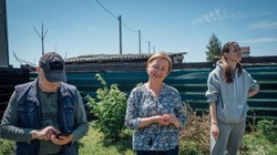 Vadym Smirnov, Alla Voloshynovych cô con gái Anastasia Smirnov đứng trên mảnh vườn đã được dọn gần hết mảnh đạn (Ảnh: Al Jazeera)