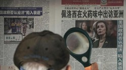 Một người dân đọc tin về bà Pelosi trên tờ Thời báo Hoàn cầu tại một sạp báo ở Bắc Kinh (Ảnh: AP)