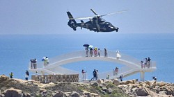 Du khách đứng nhìn một trực thăng quân Trung Quốc ở Bình Đàm, Phúc Kiến ngay trước khi cuộc tập trận bắn đạn thật được tổ chức ngày 4/8 (Ảnh: AFP)