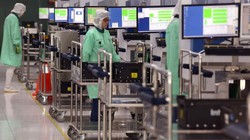 Công nhân trong một nhà máy ở Singapore nhập dữ liệu công việc vào các phương tiện tự động (Ảnh: AP)