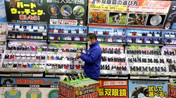 Một nhân viên cửa hàng đứng trước một cửa hàng bách hóa ở Tokyo (Ảnh: Getty)