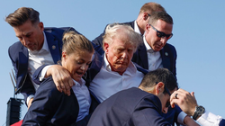 Ông Donald Trump được các nhân viên mật vụ bảo vệ khi rời khỏi khán đài ở Butler, Pennsylvania (Ảnh: CNN)