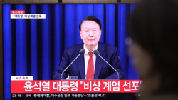 Một người dân theo dõi Tổng thống Yoon Suk Yeol tuyên bố thiết quân luật vào tối 3/12 tại ga Seoul. Ảnh: Yonhap.