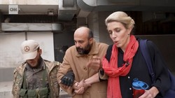 Hình ảnh tù nhân (giữa) được nhà báo Clarissa Ward (phải) của CNN và một người đàn ông có vũ trang hộ tống khỏi nhà giam ở Syria. Ảnh: CNN.