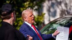 Tổng thống Donald Trump cầm tờ tiền có ghi giá xe Tesla trên đó. Ảnh: Getty.