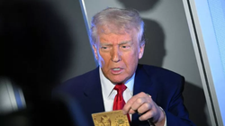 Tổng thống Mỹ Donald Trump cầm Thẻ vàng trị giá 5 triệu USD khi phát biểu với các phóng viên trên chuyên cơ Không lực Một, trên đường đến Miami vào ngày 3/4. Ảnh: AFP.