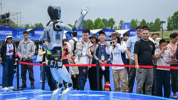 Du khách xem một chú robot biểu diễn trong lễ hội robot thế giới ở Vũ Hán tuần này. Ảnh: Xinhua.