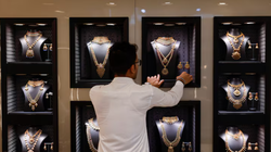 Một nhân viên đang sắp xếp vòng cổ vàng tại một cửa hàng trang sức ở Mumbai, Ấn Độ, ngày 20/3. Ảnh: Reuters.