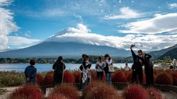 Khách du lịch chụp ảnh với núi Phú Sĩ ở phía sau tại tỉnh Yamanashi, Nhật Bản. Trung Quốc đã ban hành một số cảnh báo du lịch, kêu gọi công dân tránh xa Nhật Bản trong bối cảnh căng thẳng ngoại giao. Ảnh: AFP.