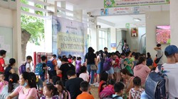 Học sinh tiểu học xếp hàng chờ nhận sách. (Ảnh: Minh Thúy)