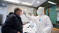 Bác sĩ đo thân nhiệt cho bệnh nhân. Ảnh: The Straitstimes