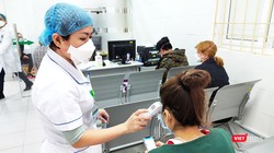 Bác sĩ kiểm tra thân nhiệt bệnh nhân. Ảnh: Minh Thúy