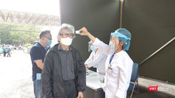 Nhân viên y tế đo thân nhiệt cho người dân tại Bệnh viện Hữu Nghị. Ảnh: Minh Thúy