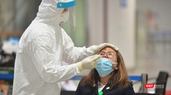 Nhân viên y tế lấy dịch mũi xét nghiệm COVID-19 cho cán bộ làm việc tại sân bay Nội Bài. Ảnh: Hoàng Anh